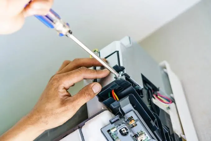 Technician repairing the control board of an aircon indoor unit